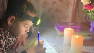 Read more about the article Com apagões, crianças ucranianas usam lanternas para fazer lição de casa; veja fotos